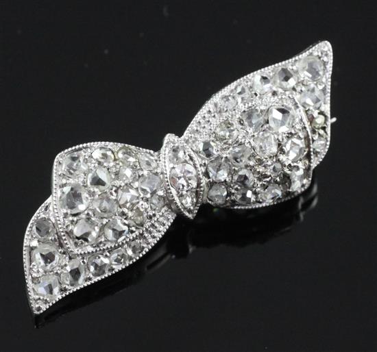 An 18ct white gold, platinum and rose cut diamond set ribbon bow brooch, approx. 1in.